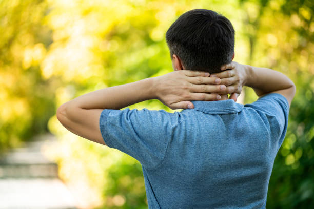 istock Neck pain when walking outdoors, man with backache on nature background 1344007161