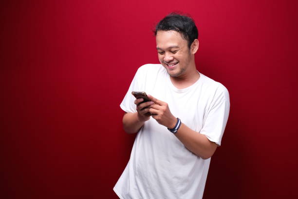istock Young asian man shocked when he looking and pointing smartphone 1344008462