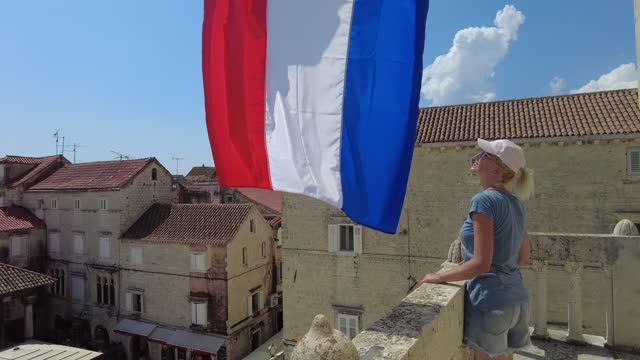 Young lady by Croatian flag in Trogir