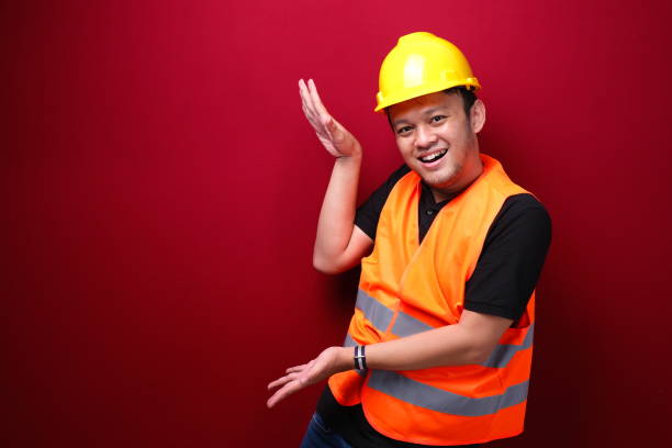 istock Smile and happy young asian man worker is with with hand point on empty space 1344010713