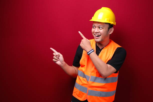 istock Smile and happy young asian man worker is with with hand point on empty space 1344010717