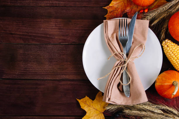 istock Happy Thanksgiving Day. Festive table setting on brown wooden background. Place for text. 1344012397