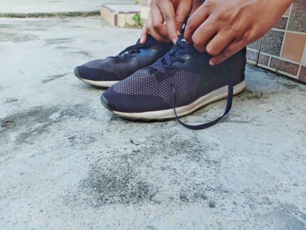 a young man is tying his shoelaces