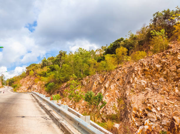 istock Dry asphalt empty automobile road with concrete barrier and marking lines on a sunny summer day with blue cloudy sky. Car travel trip concept background 1344014009