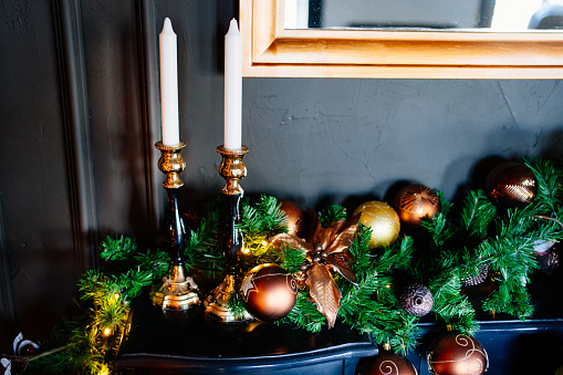 candles in a candlestick and beautiful New Year's wreath on the mantelpiece. decorating the house for Christmas. shop of goods for interior decoration. sale.