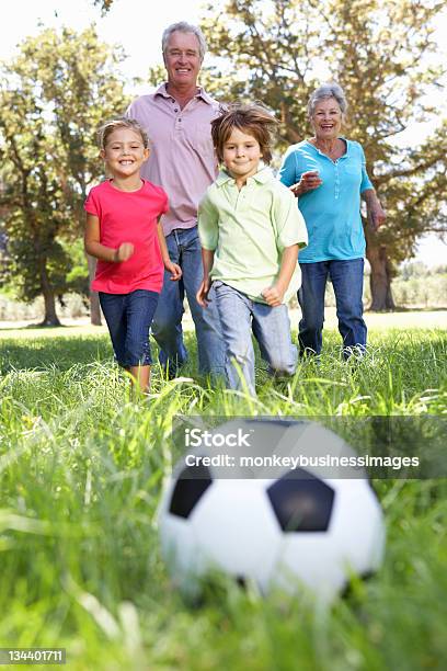 Nonni Con Nipoti Giocare A Calcio - Fotografie stock e altre immagini di Ambientazione esterna - Ambientazione esterna, Correre, Nipoti maschi e femmine