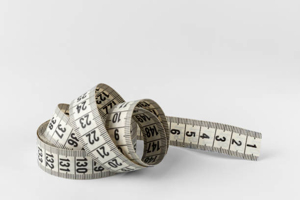 istock soft two sided tape measure roll isolated on a white and gray background with copy space 1344017371