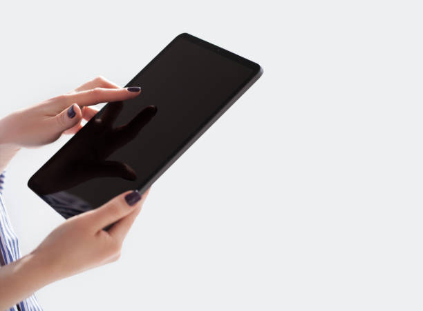 Woman holding iPad pro with white screen on white background. Office background