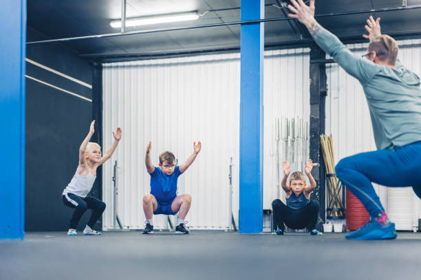 istock Boys exercising with male instructor in gym 1344019777