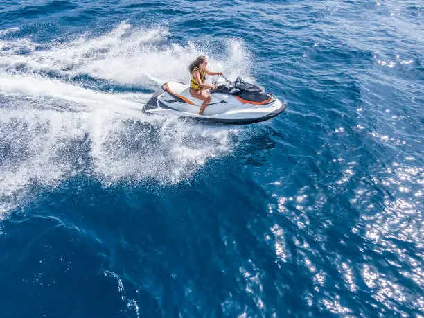 Photo of Aerial view of jet skier in blue sea. Jet ski in turquoise clear water racing stock photo