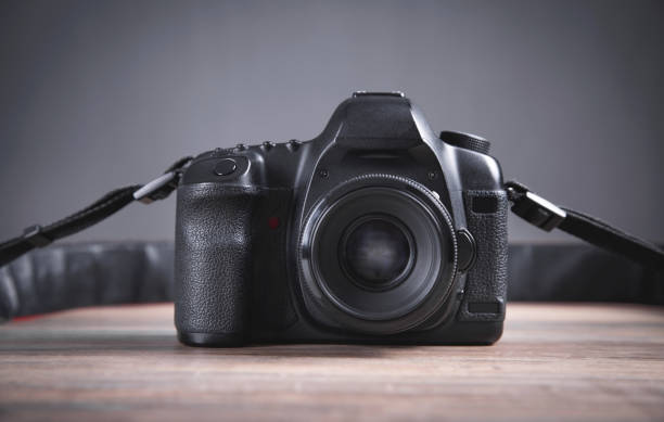 istock Professional DSLR camera on the wooden table. 1344023168