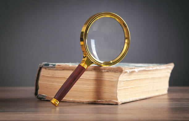 istock Magnifying glass with book on the table. 1344023169