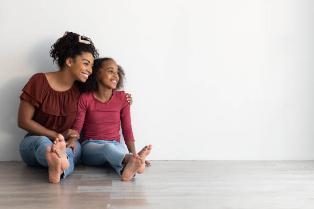 istock Cheerful black mother and daughter looking at copy space 1344024821