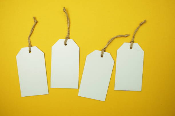 istock Flat lay White Blank Tag on yellow background 1344028919