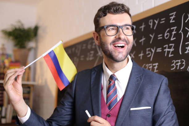 south american educator holding the colombian flag in classroom - 哥倫比亞 國家 個照片及圖片檔