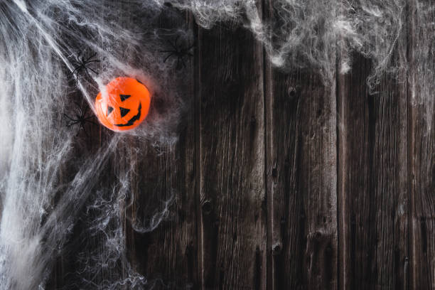 istock Spider web on wooden background with toy halloween pumpkin. Copy space. Selective focus. 1344030505