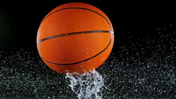 istock Falling basketball ball on water surface, black background. 1344036133