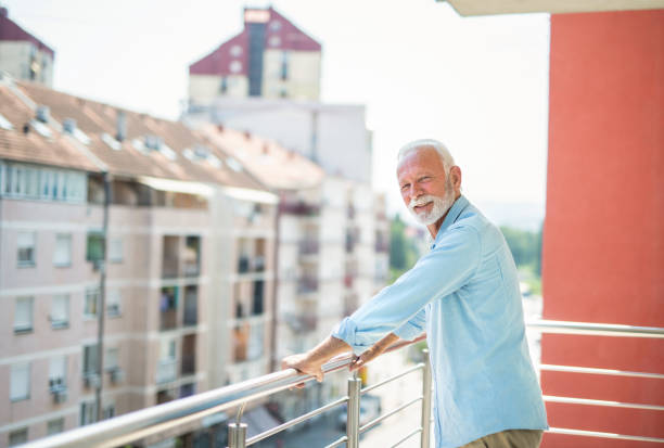 istock Senior man relaxing on balcony and looking at camera. 1344036152