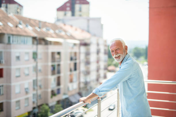 istock Senior man relaxing on balcony and looking at camera. 1344036168