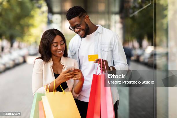 Portrait Of Happy Afro Couple Using Smartphone Holding Credit Card Stock Photo - Download Image Now