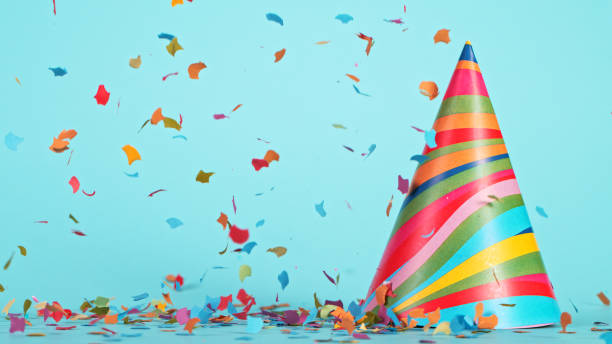 istock Colored confetti and party hat on blue background 1344038243