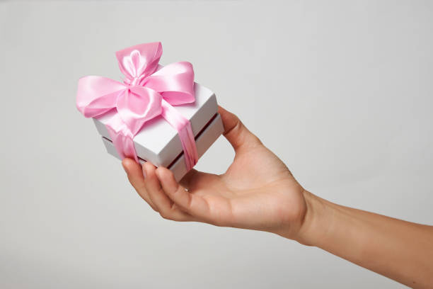 istock Female hands holding small gift box with ribbon on white background 1344038354