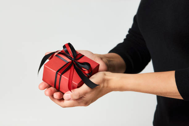 istock Woman hands holding small gift box with ribbon 1344038421
