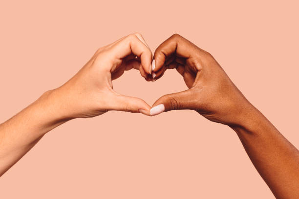 istock Black and white female hands in heart shape 1344040239