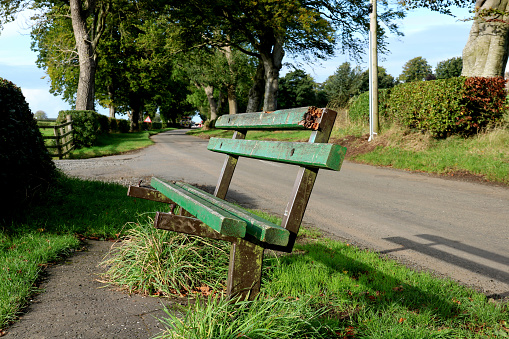 Old broken bench seat situated on a country road