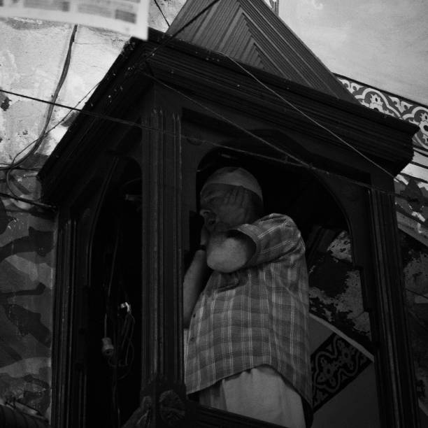 iman calling to pray at the pulpit of the grand bazaar. - black and white koran istanbul men imagens e fotografias de stock