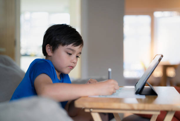 istock Portrait of preschool kid using tablet for his homework,Child drawing by using digital tablet searching information on internet,E-learning or Home schooling education concept 1344044625