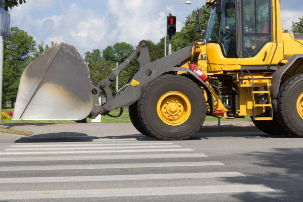 istock yellow excavator on crosswalk 1344045835