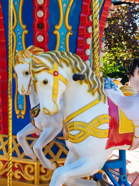 Photo of carousel with white horses in holiday park
