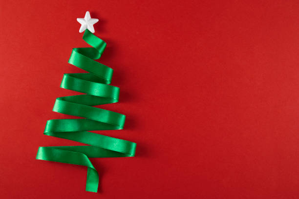 istock Green Ribbon Forming a Christmas Tree on Red Background 1344053119