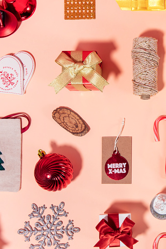 Christmas related objects and ornaments  flat lay on pink background
