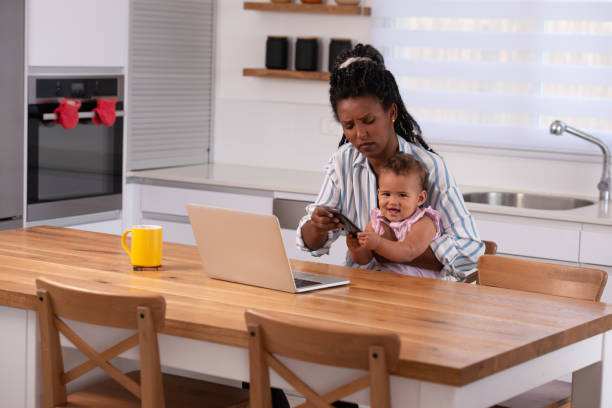 istock A woman trying to work while holding her baby. 1344056161