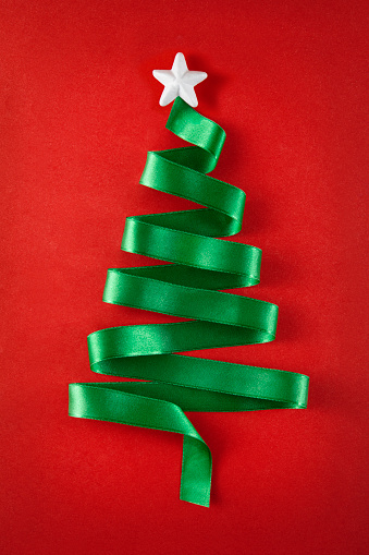 Christmas tree was made of green ribbon on red background
