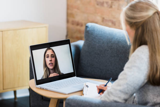 During Delta virus outbreak, therapist meets client through online therapy During a fresh outbreak of the coronavirus, the unrecognizable mature adult female counselor uses online therapy to meet with her young adult female client. melancholy computer support specialist stock pictures, royalty-free photos & images