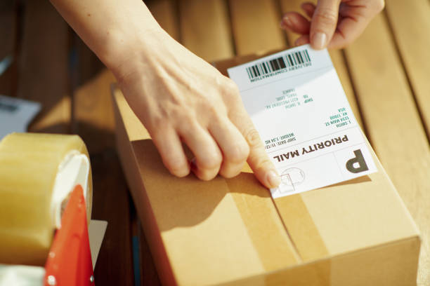 istock Modern female in warehouse applying shipping label to parcel 1344060148