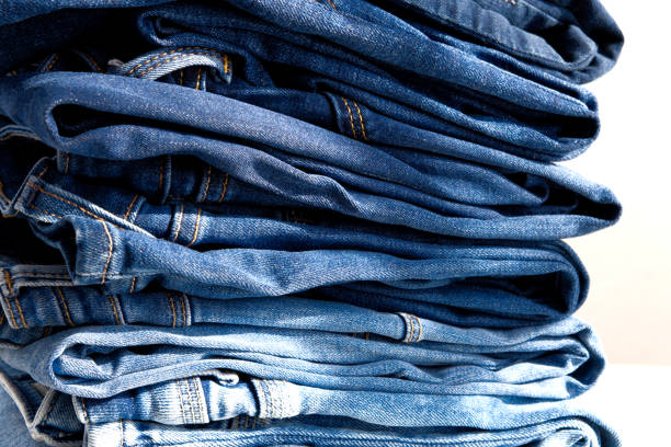 istock a pile of blue jeans on a white background. Sunlight. Close up 1344071304