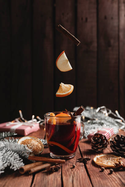 テーブルの上にマールワインのクリスマスカップ、シナモンスティックを浮上、オレンジ、リンゴ - mulled wine christmas tea heat ストックフォトと画像