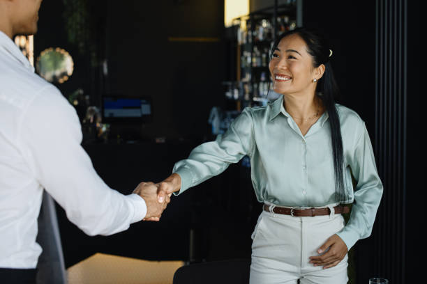 istock Smiling businessmen shaking hands before sitting down at table for meeting 1344081993