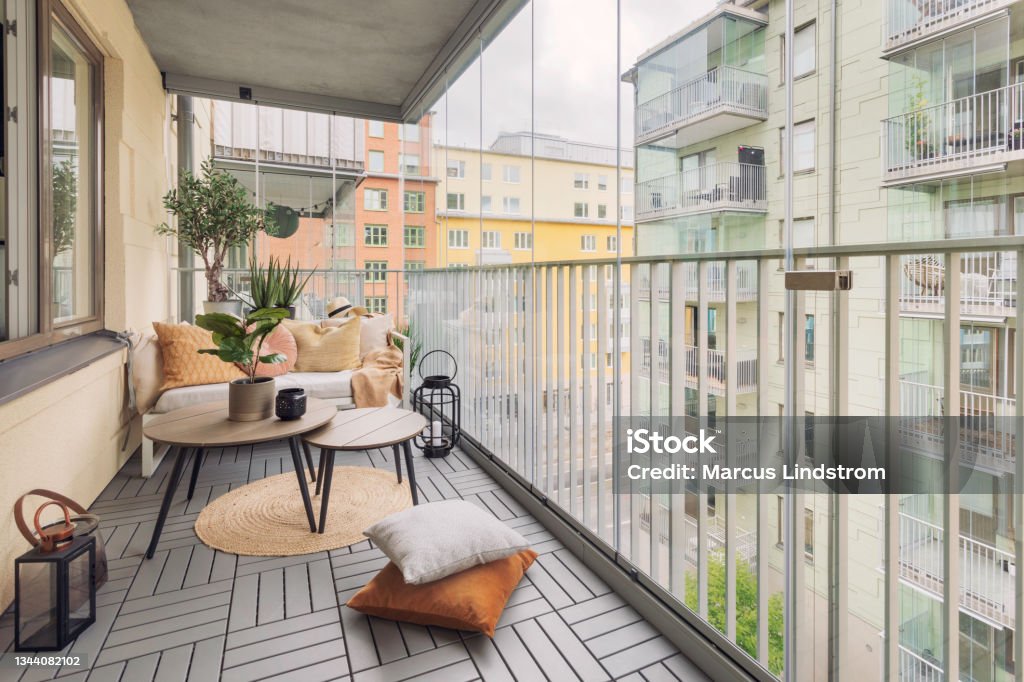 Large glass enclosed balcony A large glass enclosed balcony with a small sofa, tables and various home decor. Balcony Stock Photo