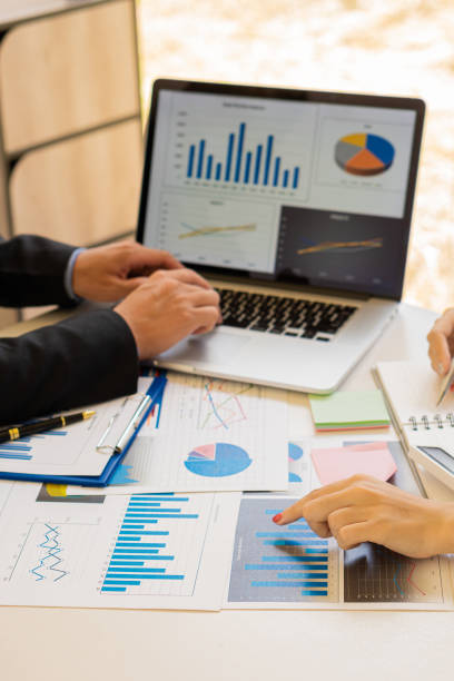 istock Vertical picture of business people analyzes and discusses and brainstorms data, charts, financial reports in the conceptual work consulting office. An accountant working on a desk using a calculator to calculate finances. 1344083980