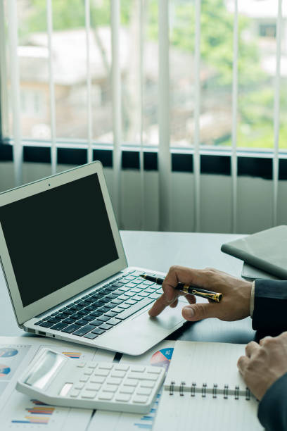 istock Vertical picture of business people analyzes and discusses and brainstorms data, charts, financial reports in the conceptual work consulting office. An accountant working on a desk using a calculator to calculate finances. 1344083996