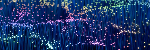 istock Fiber Optic Cable technology background in blue and rainbow colors with selective focus. Web banner format. 1344084788