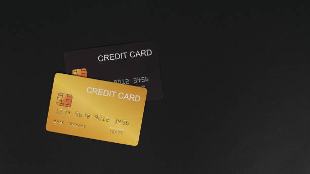 istock Black and gold credit card isolated on black background. 1344086869