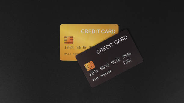 istock Black and gold credit card isolated on black background. 1344086880