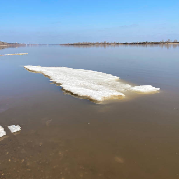 istock Spring thawed ice on lake. Background texture. Frozen ice and snow by river side. 1344088791