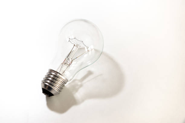 istock Light bulb turned off, on white surface. Shadow of the light bulb. 1344090063